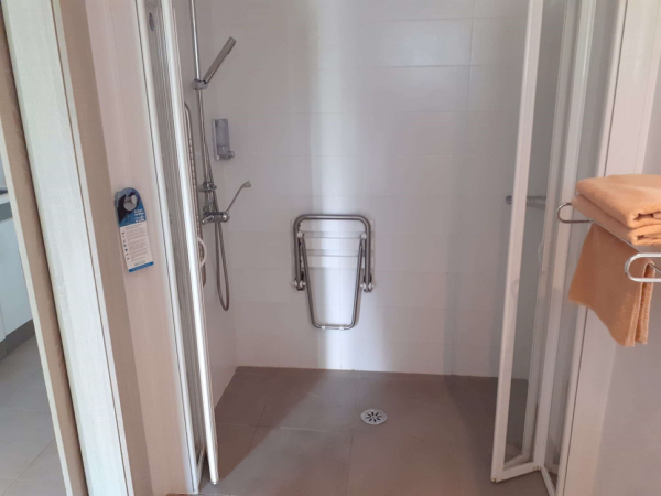 Level access shower with drop down seat