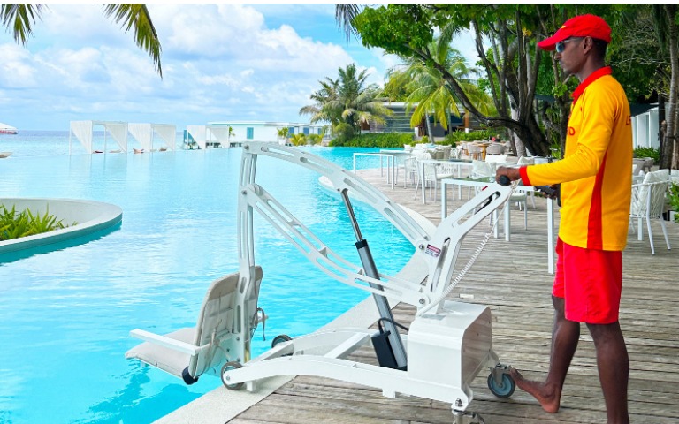 A pool hoist being operated by a member of staff over the main pool